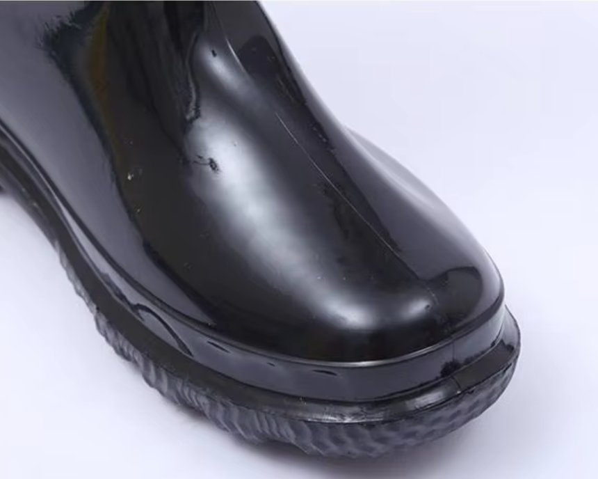 a092bfdc-7822-4703-8756-0930a4d9c5b3_tampilan_dekat_tutup_jari_kaki_membulat_pada_sepatu_bekerja_tahan_air_pvc_hangat_berwarna_hitam_glossy.png